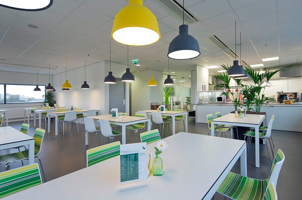 comedor corporativo con sillas rectangulares y sillas verdes de calidad